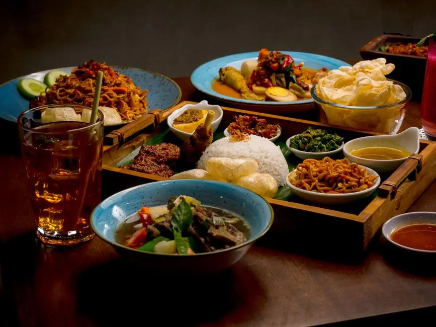 Semangkuk makanan khas praktis dengan kuah rempah dan pelengkap tradisional